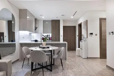 a kitchen and dining room with a table and chairs at StayMada - Peninsula Exclusive Canal Front Retreat in Dubai