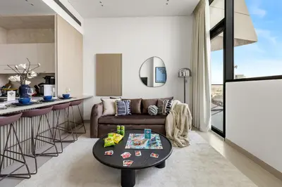 a living room and kitchen with a couch and a table at Stylish 1BR with Private Pool Near Circle Mall in Dubai