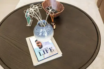 a table with a picture and a vase on it at Stylish 1BR with Private Pool Near Circle Mall in Dubai