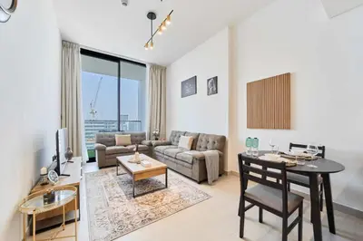 a living room with a couch and a table at Cozy 1BR Retreat in Binghatti Amber JVC in Dubai