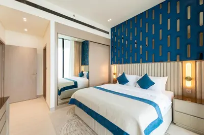 a bedroom with two beds and a blue wall at Royale Family Apartment 281 with Plunge Pool in Dubai