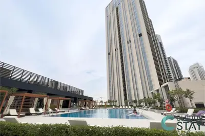a swimming pool in front of a tall building at Cloud 9 - Townhouse style 2 BR Apt with BBQ Patio in Dubai