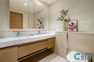 a bathroom with a sink and a mirror and a toilet at Cloud 9 - Townhouse style 2 BR Apt with BBQ Patio in Dubai