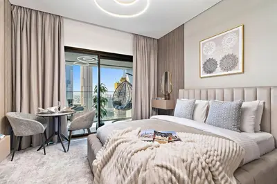 a bedroom with a large bed and a table and chairs at The Smart Concierge - Peninsula One in Dubai