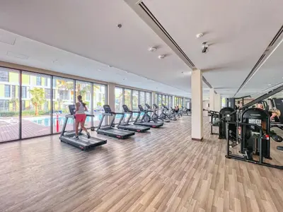 a room with a row of treadmills in a gym at Cozy City-View Studio w Balcony & Queen Bed in Dubai