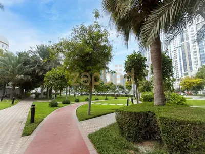 a park with palm trees and a walkway at Zapbed House Luxury 2BR at Boulevard Point Walk to Dubai Mall in Dubai