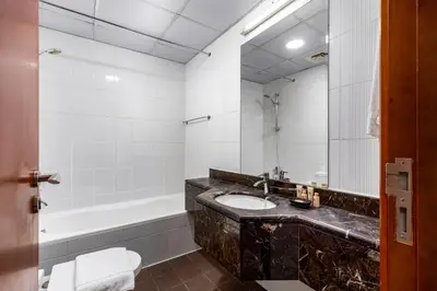 a bathroom with a sink and a bath tub at Maison Privee - Comfortable Downtown Apartment with City Skyline Vws in Dubai