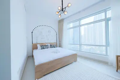 a white bedroom with a bed and a window at Premium Burj Khalifa View Downtown Dubai in Dubai
