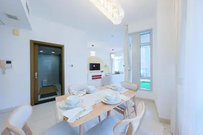 a kitchen and dining room with a wooden table and chairs at Premium Burj Khalifa View Downtown Dubai in Dubai