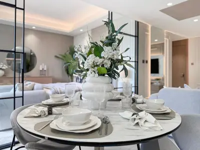 a dining room table with a vase of flowers on it at Modern 1BR Escape with Balcony View in Dubai