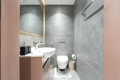a bathroom with a white sink and a toilet at Modern 1BR Escape with Balcony View in Dubai