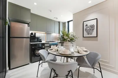 a kitchen with a table and chairs and a refrigerator at Modern 1BR Escape with Balcony View in Dubai