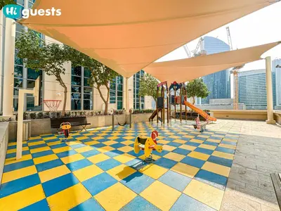 a playground with children playing on a checkered floor at HiGuests - Family Friendly 1BR Near Burj Khalifa in Dubai