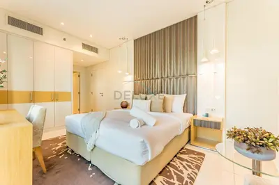 a bedroom with a large white bed and a desk at Prime Waterfront Living, Just Moments from Marine Transport, Bus Stops, and Dubai Water Canal, Waters Edge, Business Bay by Deluxe Holiday Homes in Dubai