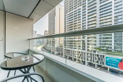 a balcony with a table and chairs and a large window at Prime Waterfront Living, Just Moments from Marine Transport, Bus Stops, and Dubai Water Canal, Waters Edge, Business Bay by Deluxe Holiday Homes in Dubai