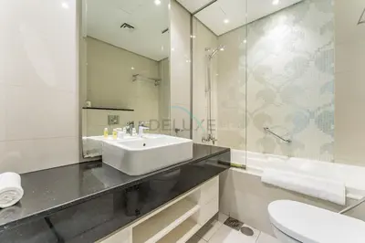 a white bathroom with a sink and a mirror at Prime Waterfront Living, Just Moments from Marine Transport, Bus Stops, and Dubai Water Canal, Waters Edge, Business Bay by Deluxe Holiday Homes in Dubai