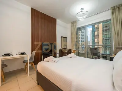 a hotel room with a bed and a desk and a window at Zapbed Stylish Studio Boulevard Central 2 Down Town Dubai in Dubai