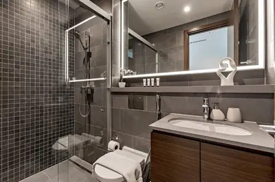 a bathroom with a toilet and a sink and a mirror at Bright 1BR in Sobha Crest B Stunning Views & Pool in Dubai