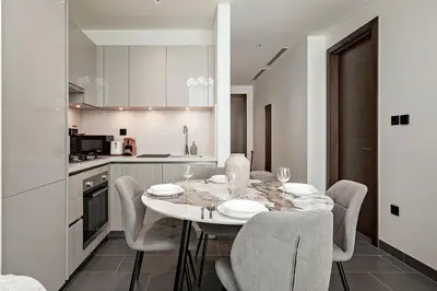 a kitchen with a table and chairs in a room at Bright 1BR in Sobha Crest B Stunning Views & Pool in Dubai