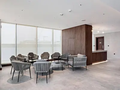 a waiting room with chairs and tables and windows at Bright 1BR in Sobha Crest B Stunning Views & Pool in Dubai