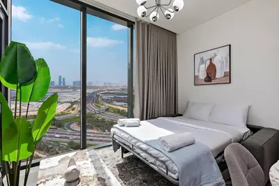 a bedroom with a bed and a large window at Bright 1BR in Sobha Crest B Stunning Views & Pool in Dubai