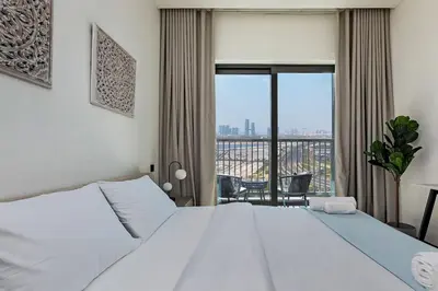 a bedroom with a white bed and a large window at Bright 1BR in Sobha Crest B Stunning Views & Pool in Dubai