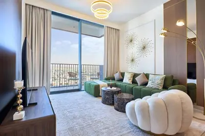 a living room with a green couch and a large window at Luxury 1BR Apartment Steps from Dubai Hills Mall in Dubai