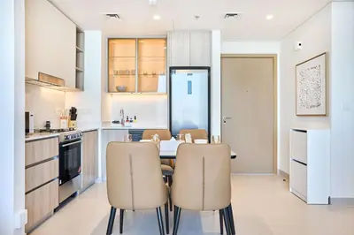 a kitchen with a table and chairs in a room at Luxury 1BR Apartment Steps from Dubai Hills Mall in Dubai