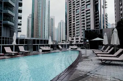 a swimming pool with lounge chairs and umbrellas in a city at Luxury 1BR Apartment near Burj Khalifa & Dubai Mall in Dubai