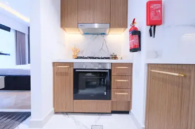 a kitchen with wooden cabinets and a stove at Modern 2BR Retreat Azizi Riviera 61 Square in Dubai