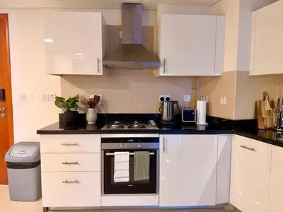 a kitchen with white cabinets and a stove top oven at Panoramic Luxury 1BR at Park Towers, DIFC, Dubai, Stunning City View in Dubai