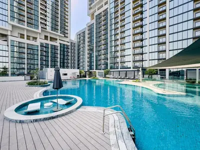 a large swimming pool in a building with tall buildings at Elegant 1BR Sobha Crest City Views in Dubai