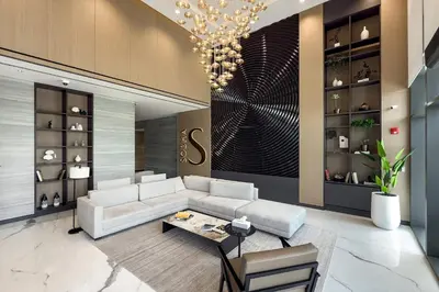 a living room with a white couch and a chandelier at Elegant 1BR Sobha Crest City Views in Dubai