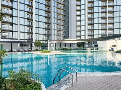 a large swimming pool in front of a large building at Elegant 1BR Sobha Crest City Views in Dubai