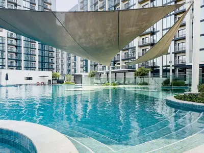 a swimming pool in a city with tall buildings at Elegant 1BR Sobha Crest City Views in Dubai