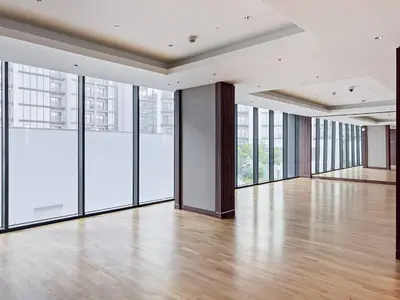 an empty room with large windows and a wooden floor at Elegant 1BR Sobha Crest City Views in Dubai