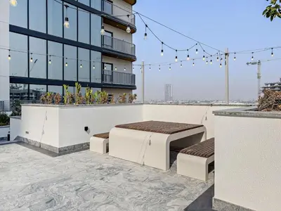 a building with two beds on a patio at Chic 1BR Retreat Sobha Crest with Pool & Gym in Dubai
