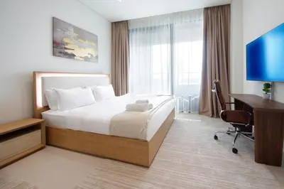 a hotel room with a bed and a desk and a computer at Wecation - Cozy Studio , Trillionaire , Private Jacuzzi in Dubai