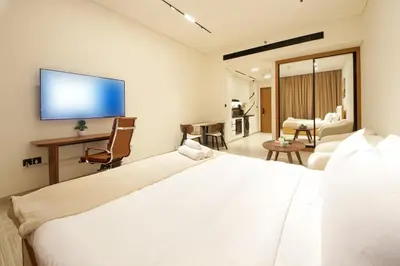 a bedroom with a large bed with a tv on the wall at Wecation - Cozy Studio , Trillionaire , Private Jacuzzi in Dubai