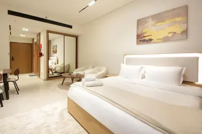 a bedroom with a large bed and a living room at Wecation - Cozy Studio , Trillionaire , Private Jacuzzi in Dubai