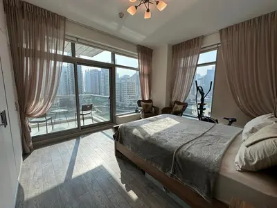 a bedroom with a bed and a large window at sanibel tower in Dubai
