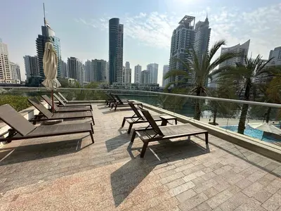 a row of benches sitting on a balcony with a city skyline at sanibel tower in Dubai