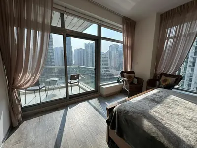 a bedroom with a bed and a large window at sanibel tower in Dubai
