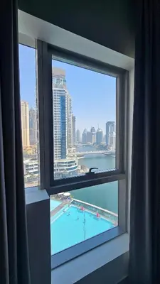 a window with a view of a swimming pool at Bay Central 1BR with Full Marina View in Dubai