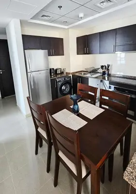 a kitchen with a table and chairs and a refrigerator at Bay Central 1BR with Full Marina View in Dubai