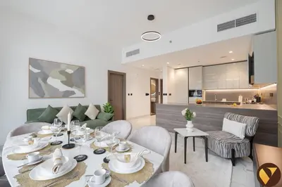 a dining room and living room with a table and chairs at Vogue Business Bay Royal Regency near Downtown, Burj Khalifa and Dubai Mall, One Bedroom Apartment with Balcony and partial Burj Khalifa view, Access to all Amenities in Dubai
