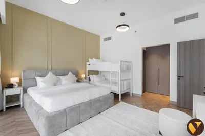 a bedroom with a large white bed and a white chair at Vogue Business Bay Royal Regency near Downtown, Burj Khalifa and Dubai Mall, One Bedroom Apartment with Balcony and partial Burj Khalifa view, Access to all Amenities in Dubai