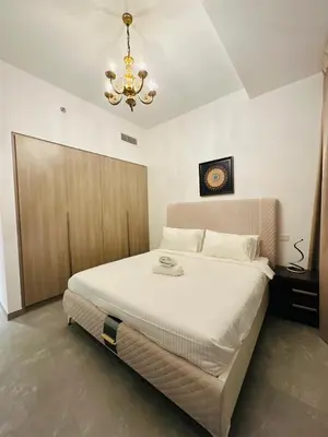 a bedroom with a large white bed with a chandelier at Amazing apartment on Stella Maris 2BR in Dubai