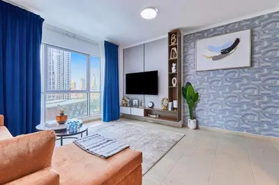 a living room with a couch and a tv at Downtown View 2BHK in Dubai