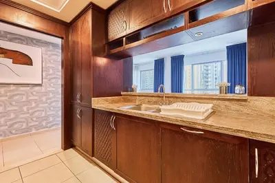 a kitchen with wooden cabinets and a sink at Downtown View 2BHK in Dubai
